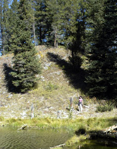 Annette pointing up hill at cache location